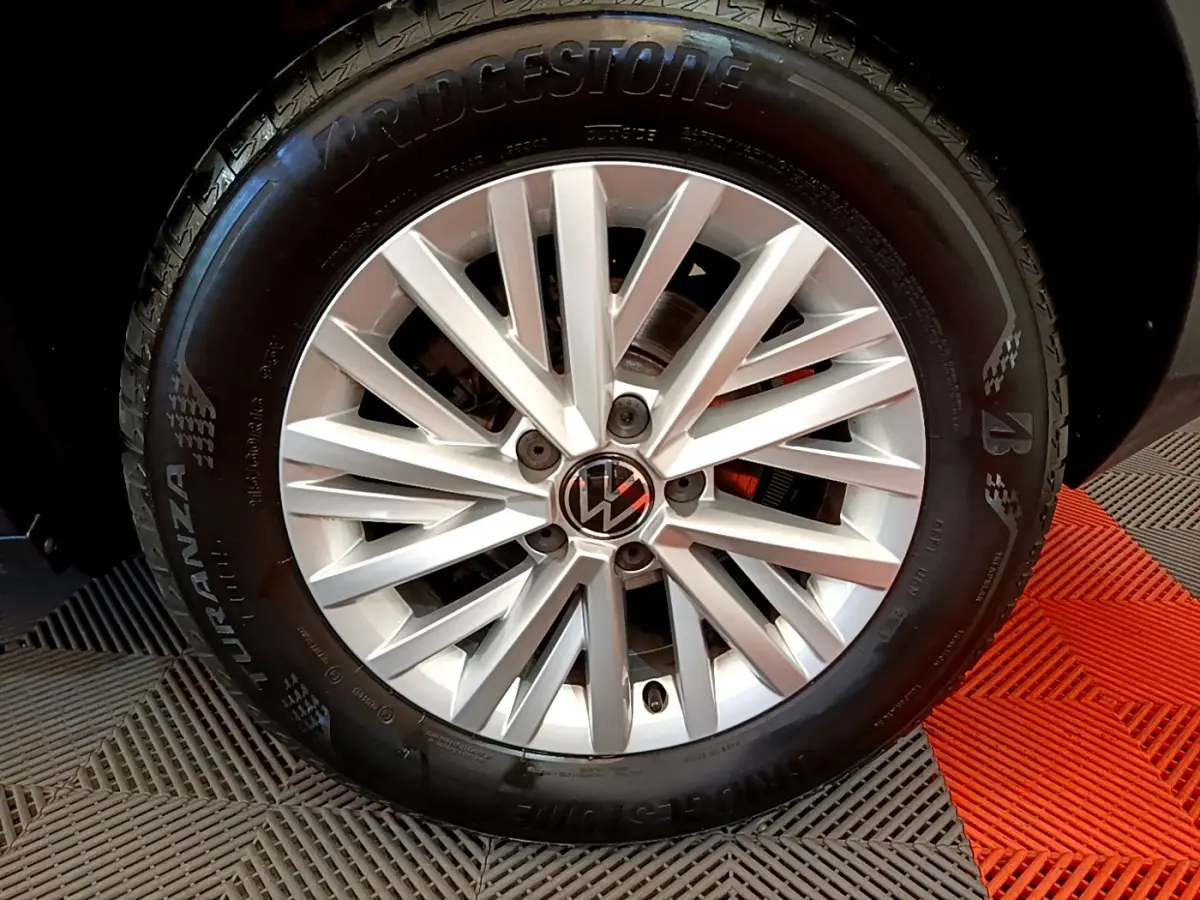 Gros plan sur la jante argentée et le pneu Bridgestone d’un Volkswagen T-Roc gris foncé.