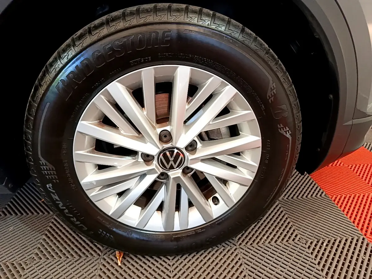 Gros plan sur la roue avant droite du Volkswagen T-Roc gris foncé avec jante alliage et pneu Bridgestone.