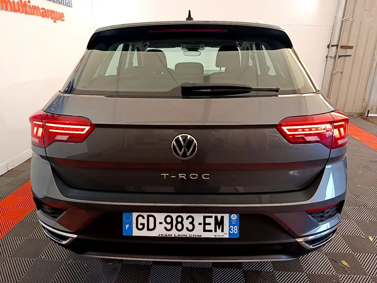 Vue arrière d'un Volkswagen T-Roc gris foncé avec feux LED allumés et plaque d'immatriculation française visible