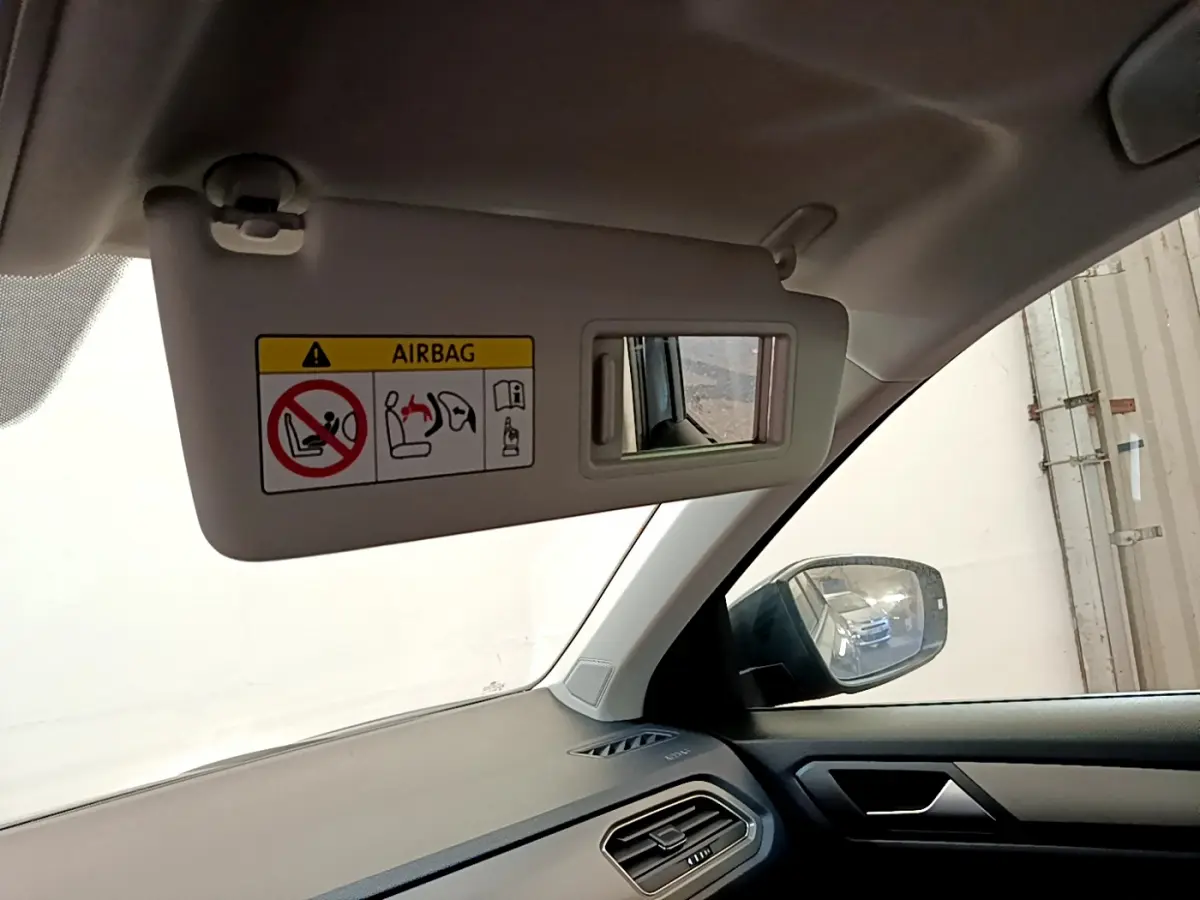 Détail du pare-soleil côté conducteur avec miroir et avertissement airbag, tableau de bord gris foncé Volkswagen T-Roc 2021.