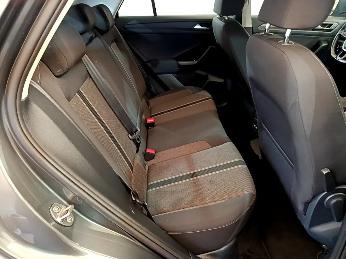 Vue intérieure côté gauche des sièges arrière gris foncé du Volkswagen T-Roc 2021 avec détails des ceintures et tissu.