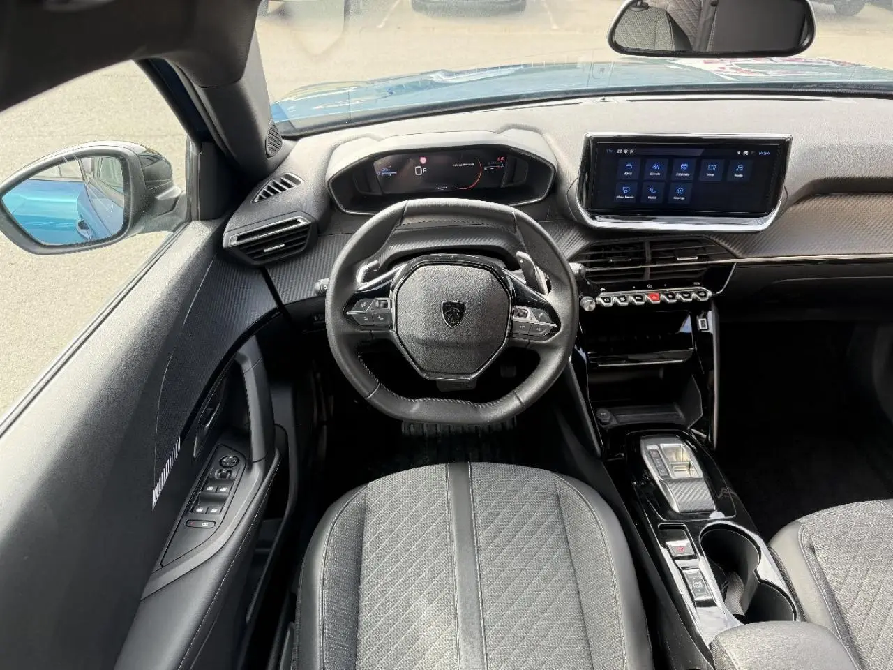 Vue intérieure avant du Peugeot 2008 2025 bleu obsession, avec tableau de bord numérique et écran tactile central.
