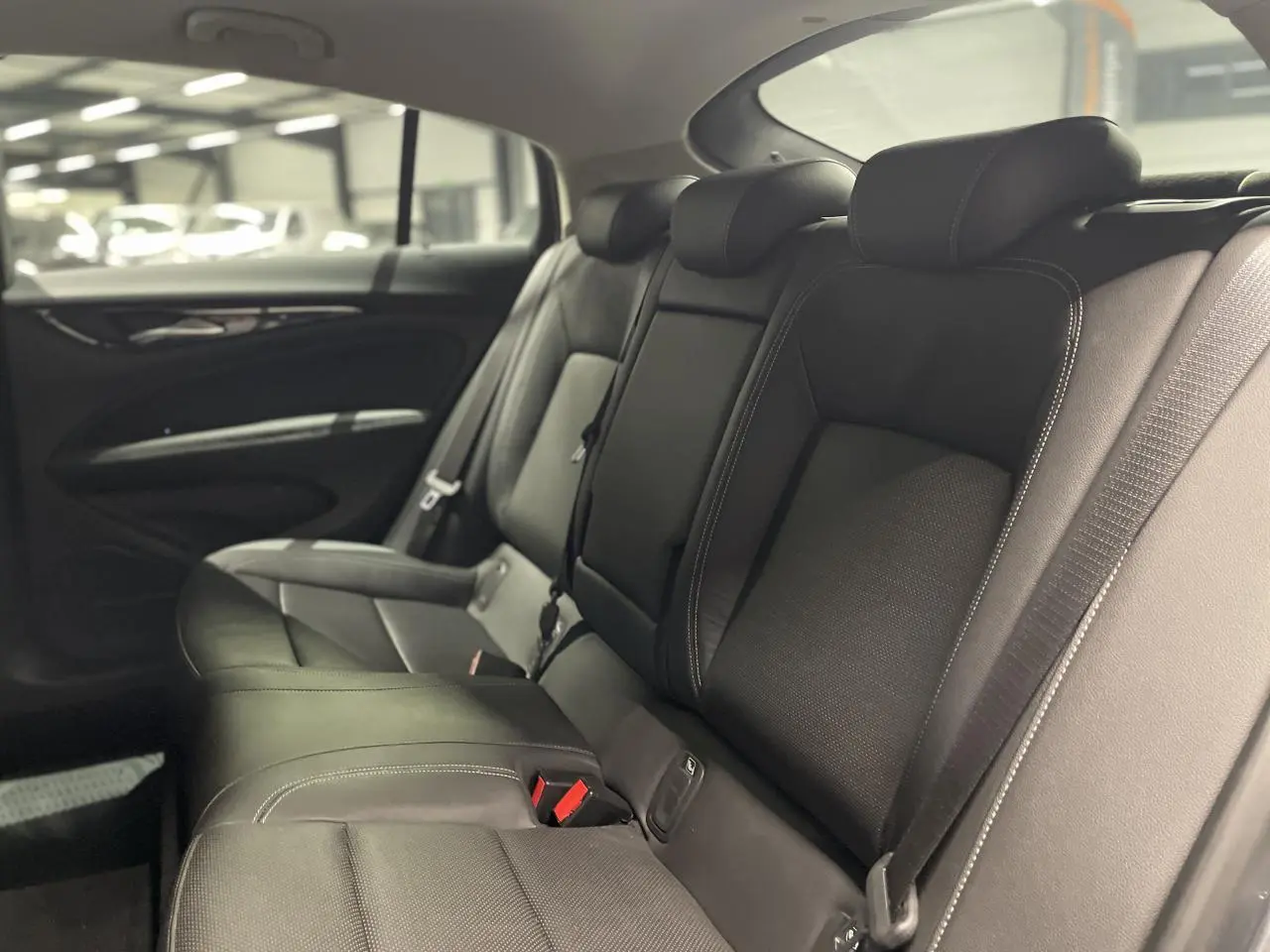 Banquette arrière en cuir noir de l'Opel Insignia Grand Sport 2021, vue côté droit avec appuie-têtes et ceintures visibles.