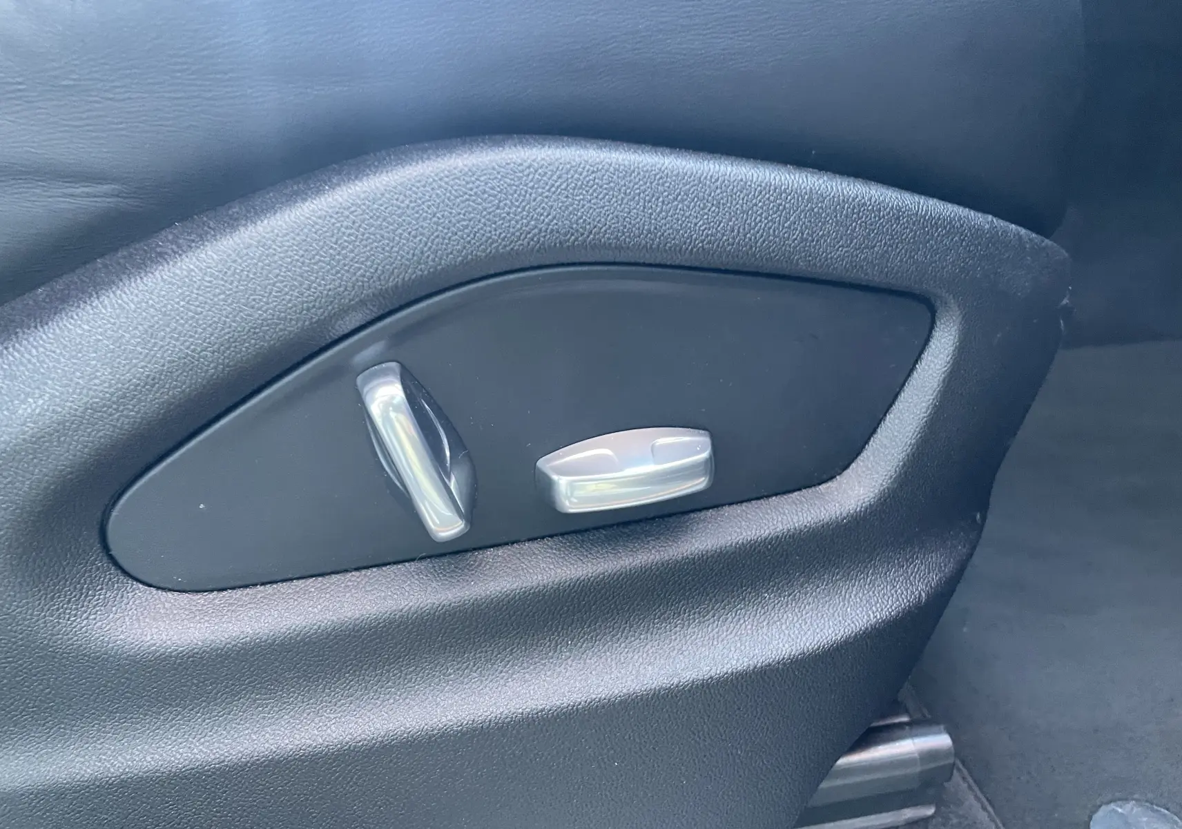 Gros plan sur les commandes électriques de réglage du siège en cuir noir du Porsche Cayenne Coupé E-Hybrid 2021.