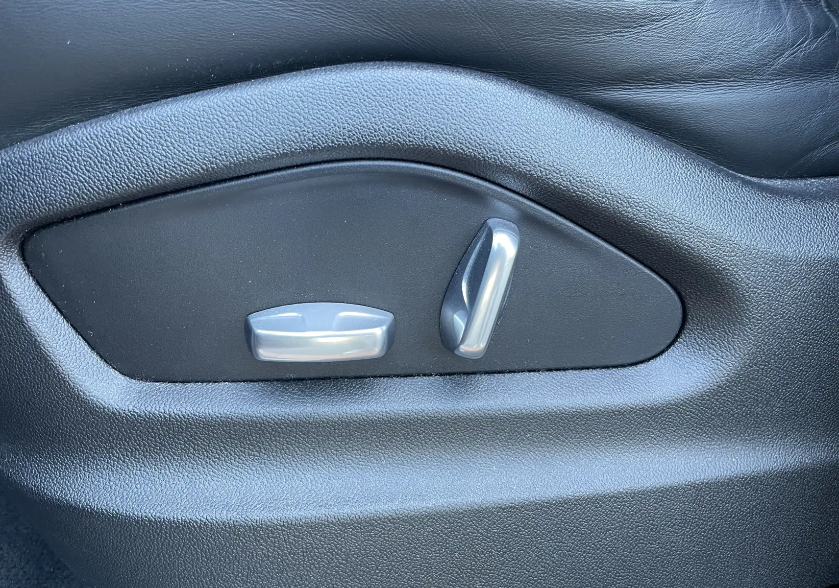 Gros plan sur les commandes de réglage électrique du siège en cuir noir d'un Porsche Cayenne Coupé E-Hybrid 2021.