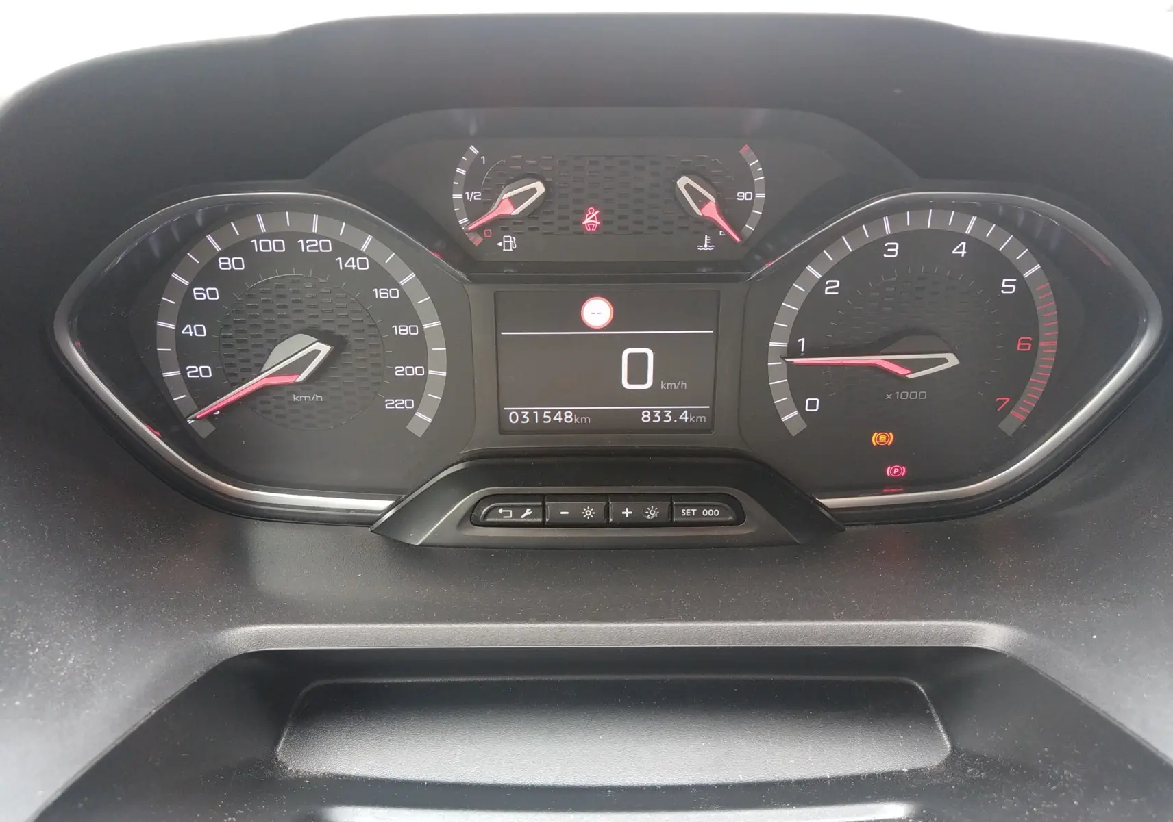 Vue rapprochée du tableau de bord numérique du Peugeot Rifter gris platinium, affichant la vitesse à 0 km/h et le compte-tours.