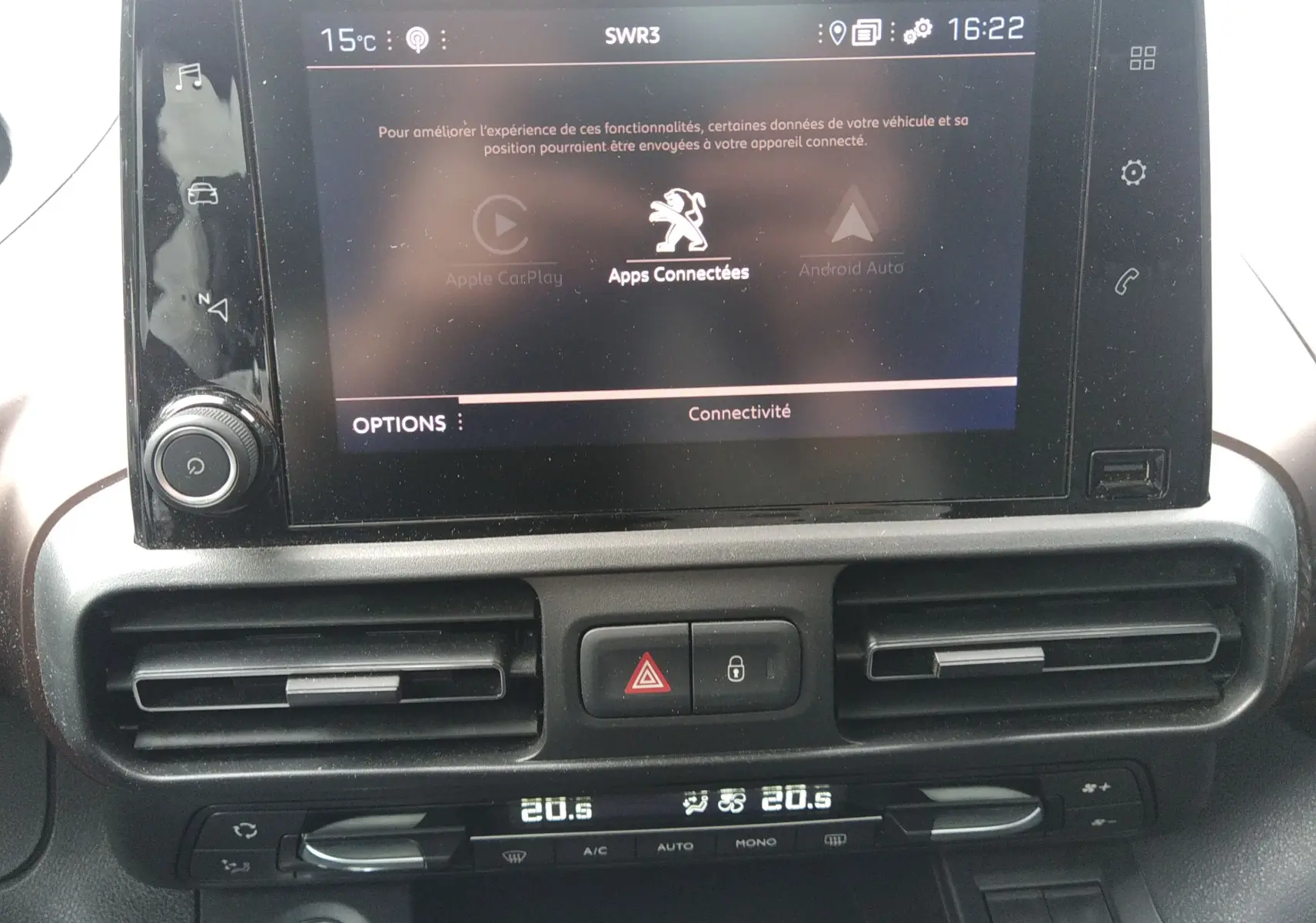 Vue rapprochée de l’écran tactile et de la console centrale du Peugeot Rifter 2022 gris platinium avec climatisation digitale.