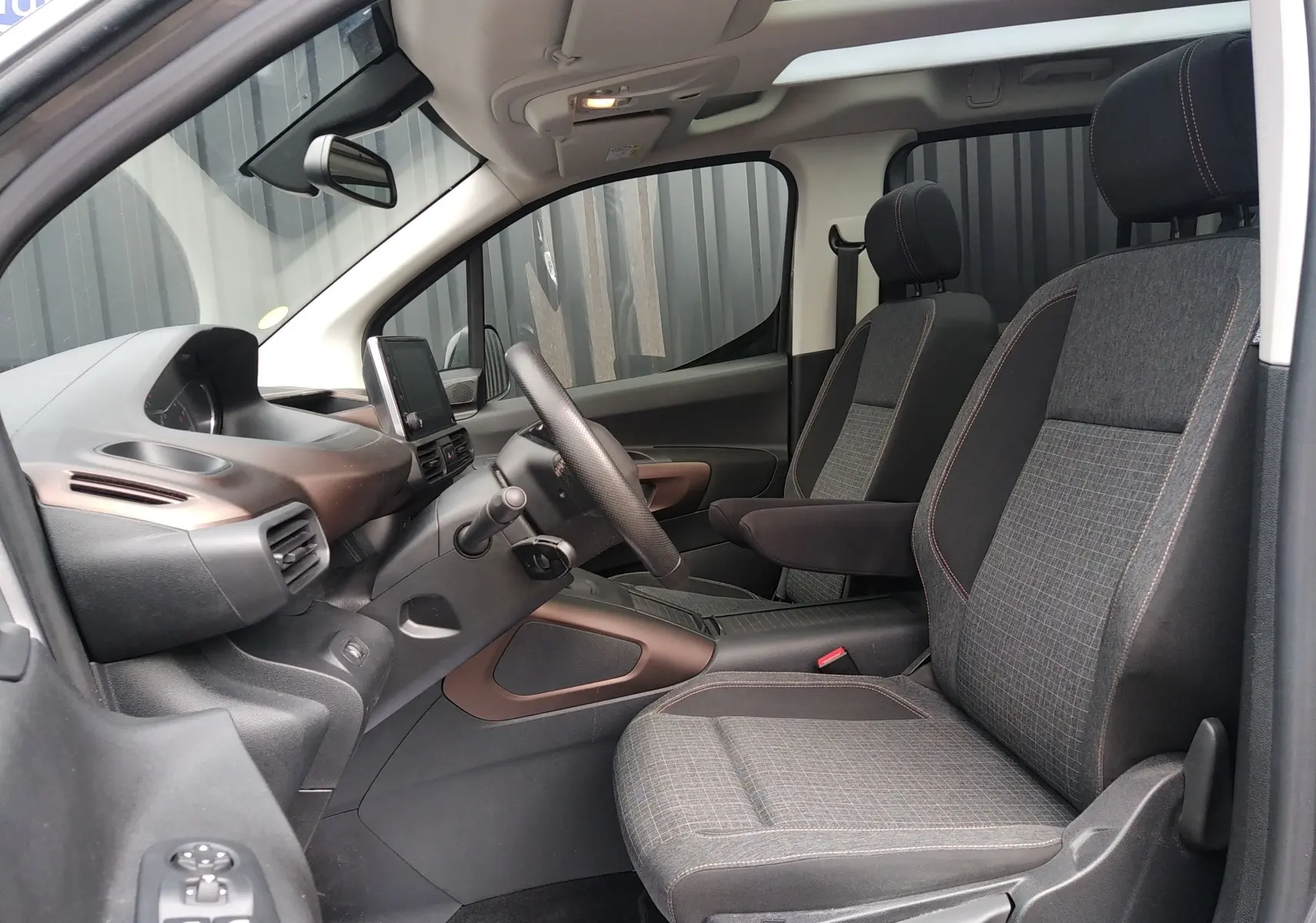 Vue intérieure côté conducteur du Peugeot Rifter 1.5 BlueHDI 130ch GT 2022 avec sièges tissu noir et toit ouvrant panoramique.