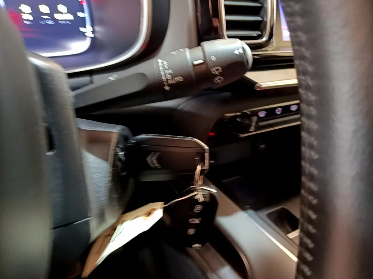 Gros plan sur la clé dans le contacteur d'une Citroën C5 Aircross 2020, tableau de bord et volant en cuir visibles.