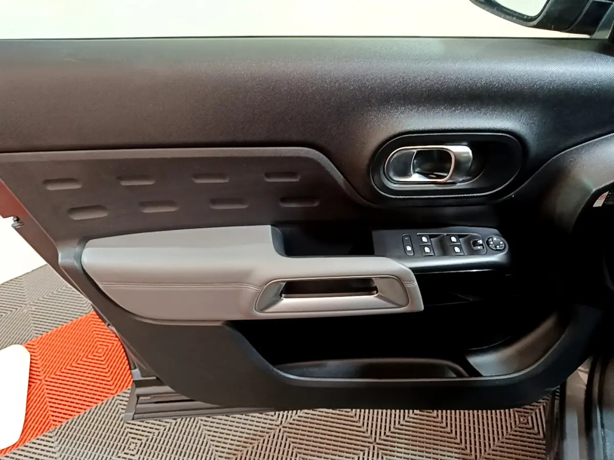 Gros plan sur la porte côté gauche du Citroën C5 Aircross 2020 gris foncé avec commandes de vitres et poignée grise.