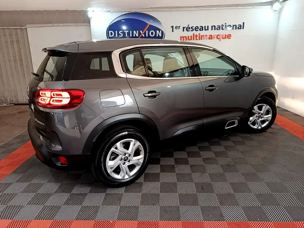 Vue 3/4 arrière droite d'un Citroën C5 Aircross gris foncé avec feux arrière LED et jantes alliage 17 pouces.