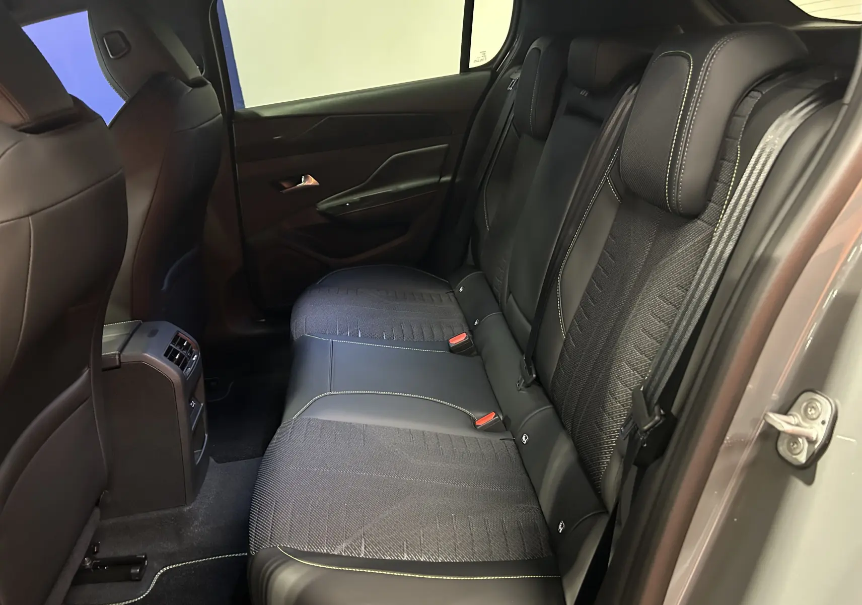 Vue intérieure côté droit des sièges arrière en cuir et tissu noir de la Peugeot 308 III Ph.2 HYBRID 145 GT Gris Selenium.