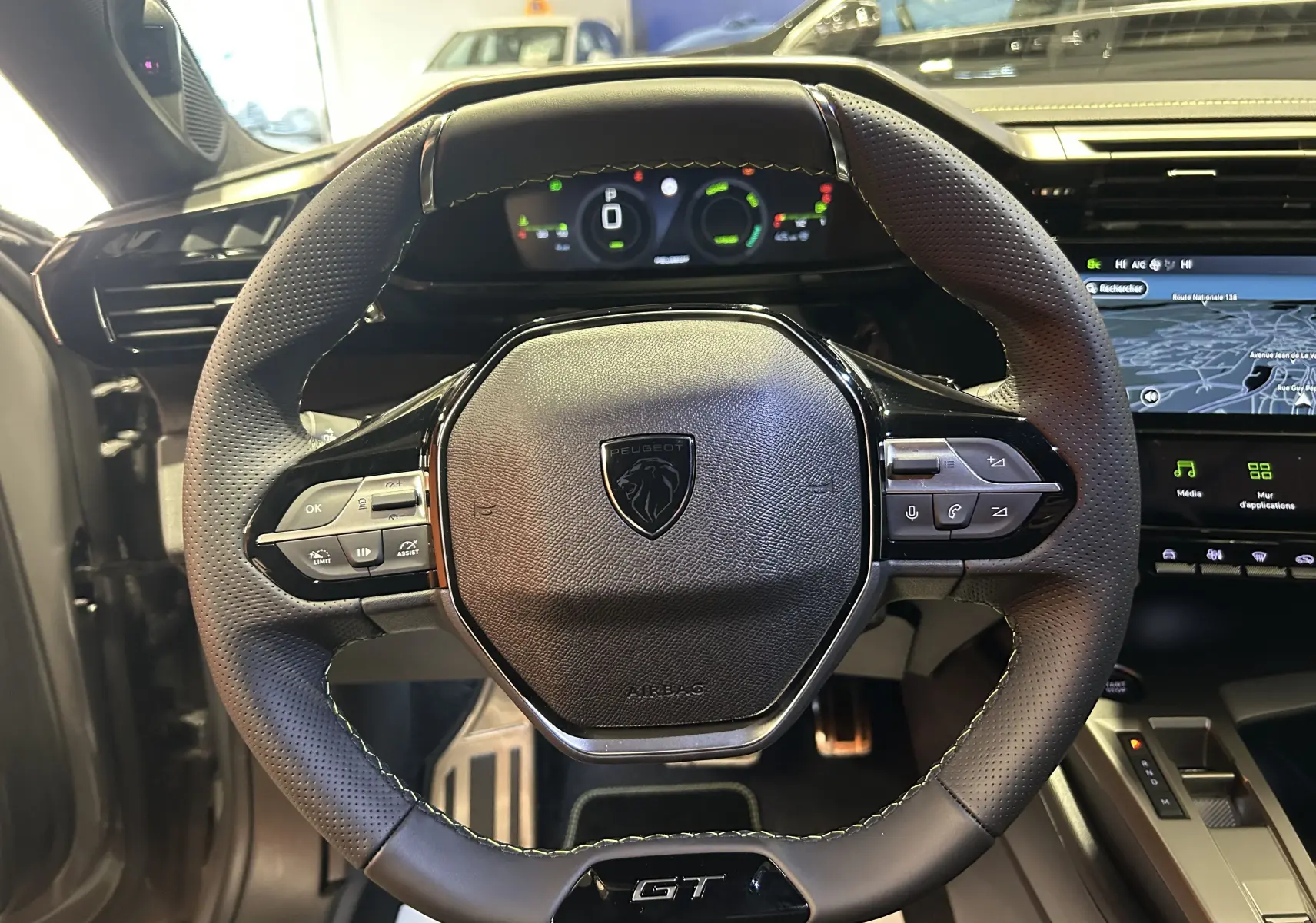 Vue rapprochée du volant GT en cuir perforé avec instrumentation numérique et écran GPS du Peugeot 308 gris Selenium.