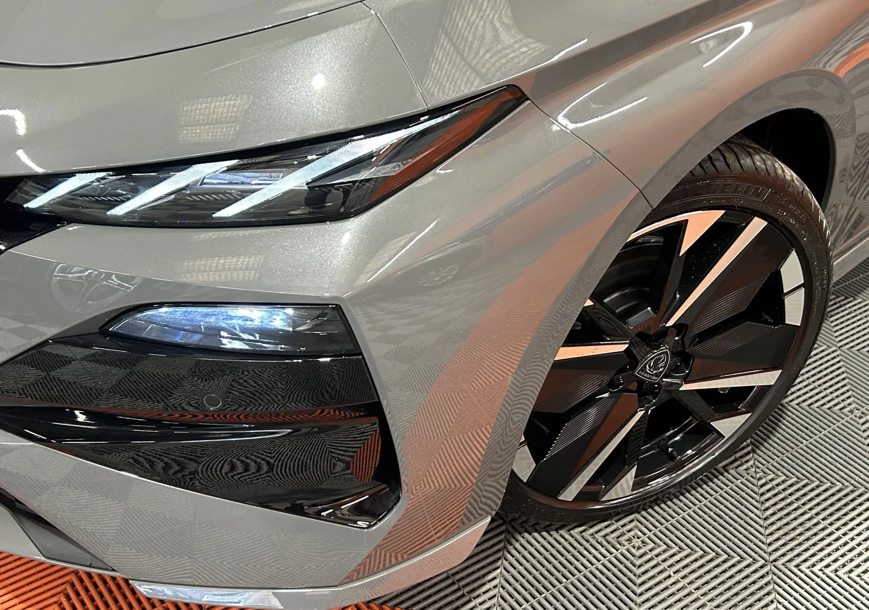 Gros plan sur l’avant droit gris Selenium du Peugeot 308 III Ph.2 HYBRID 145 GT avec optique LED et jante noire et argent.