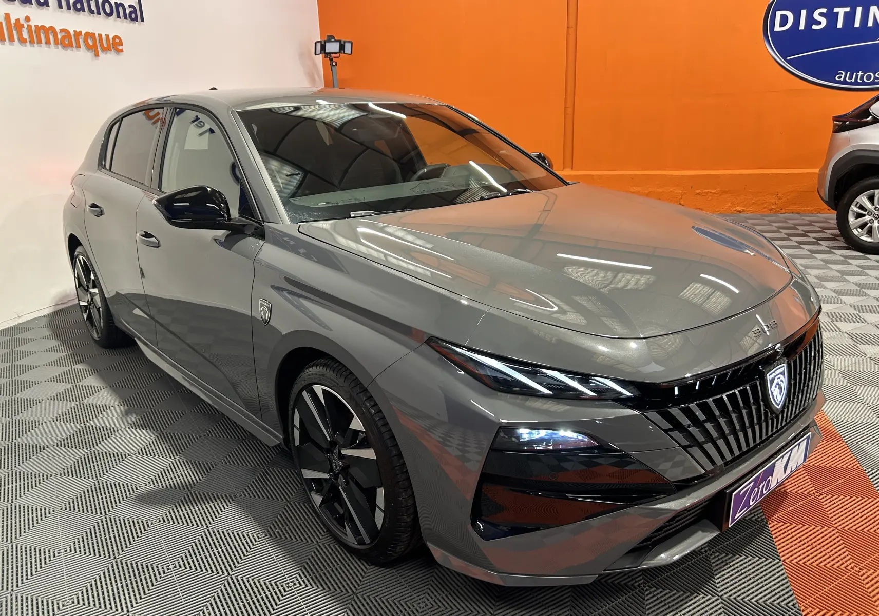 Peugeot 308 gris Selenium vue 3/4 avant droit, avec calandre noire et jantes alliage noires brillantes.