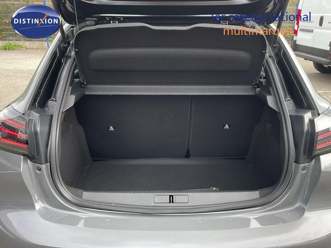 Coffre ouvert vu de l'arrière d'une Peugeot 208 1.2 PureTech 100ch gris sélénium métal avec toit noir.