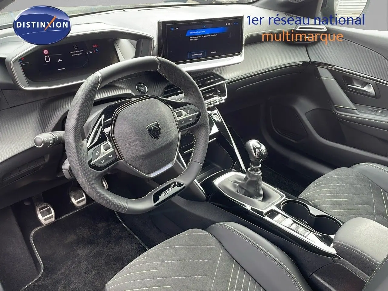 Intérieur Peugeot 208 GT 2025 vu côté conducteur, volant GT, sellerie noire et levier de vitesse manuel.