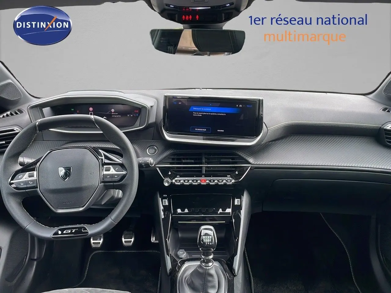Vue intérieure frontale du tableau de bord de la Peugeot 208 GT 2025 avec volant compact et écran tactile central.