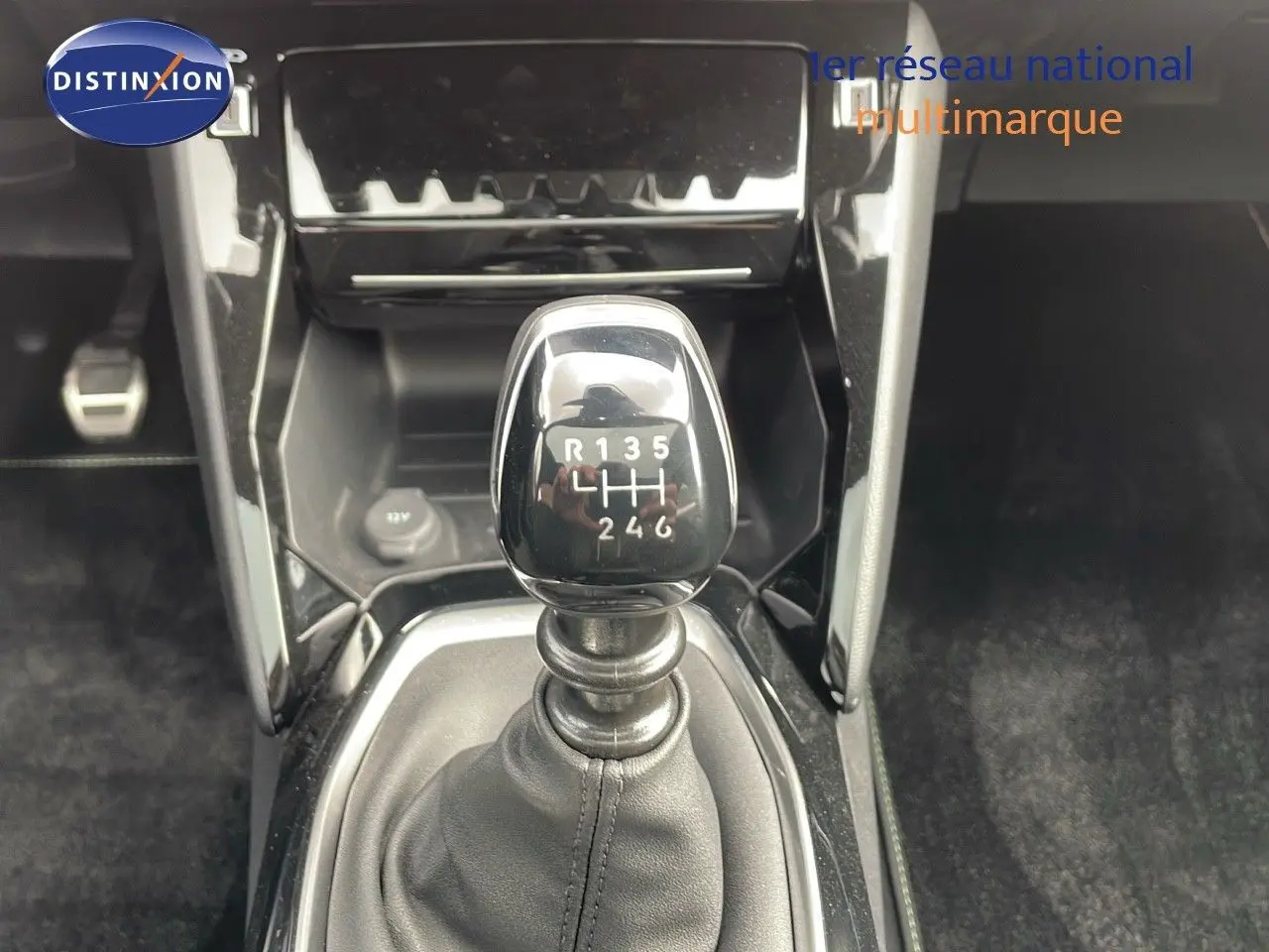 Le levier de vitesse manuel noir brillant de la Peugeot 208 1.2 PureTech GT, vue rapprochée intérieure.