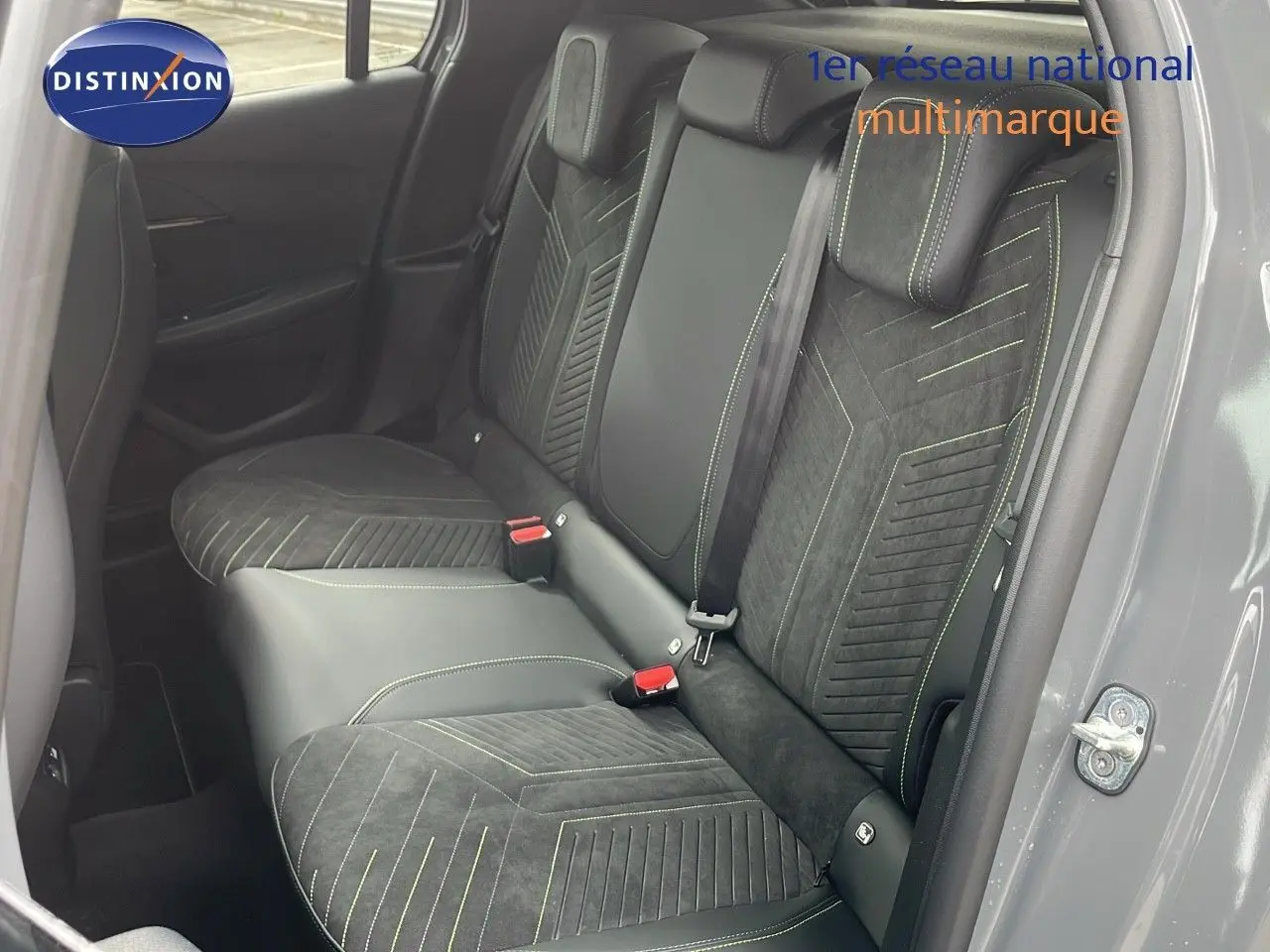 Vue intérieure côté droit des sièges arrière en cuir noir et alcantara avec surpiqûres vertes d'une Peugeot 208 gris sélénium métal.
