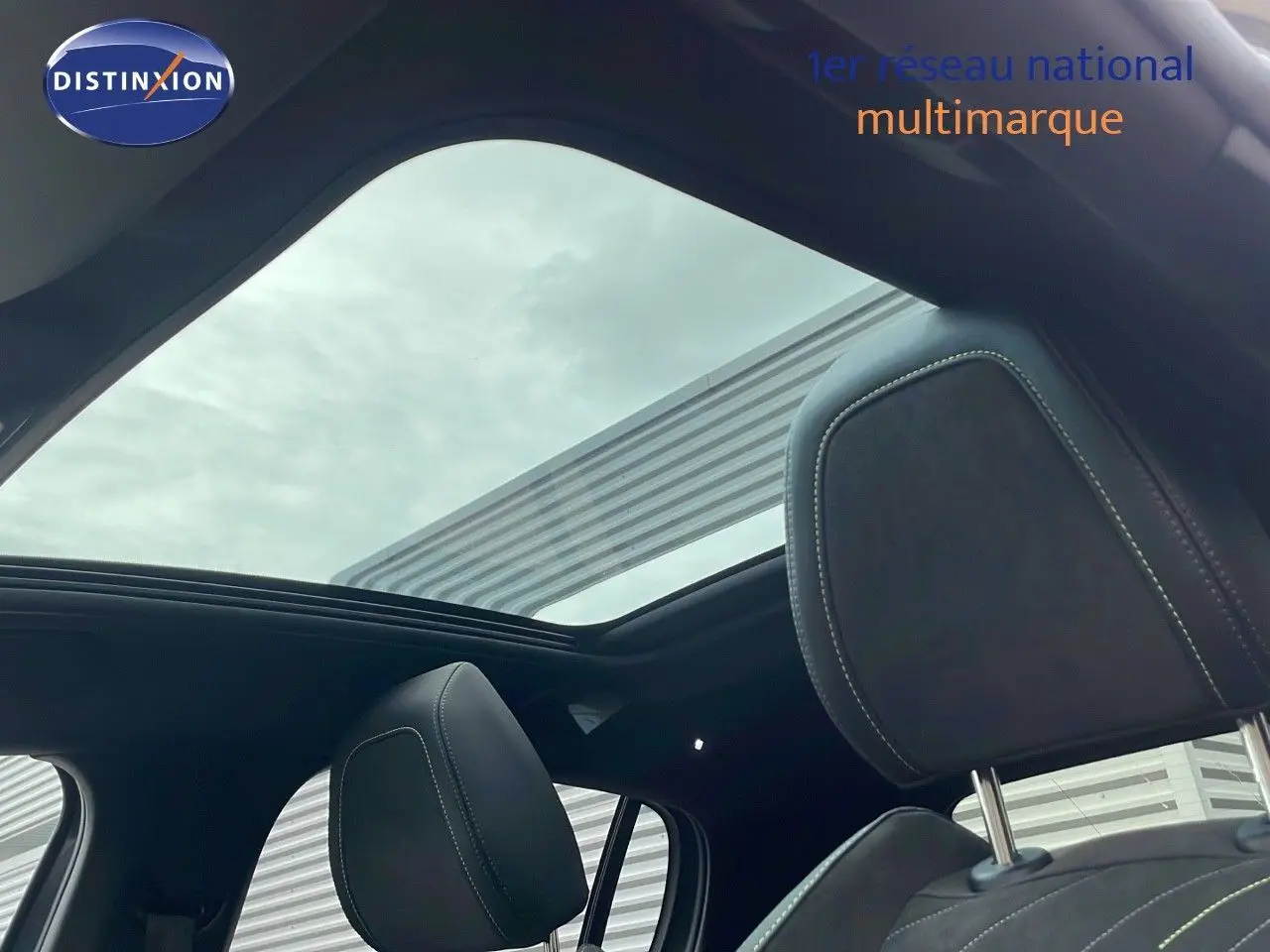 Vue intérieure du toit ouvrant panoramique et des sièges avant en cuir noir d'une Peugeot 208 gris sélénium 2025.