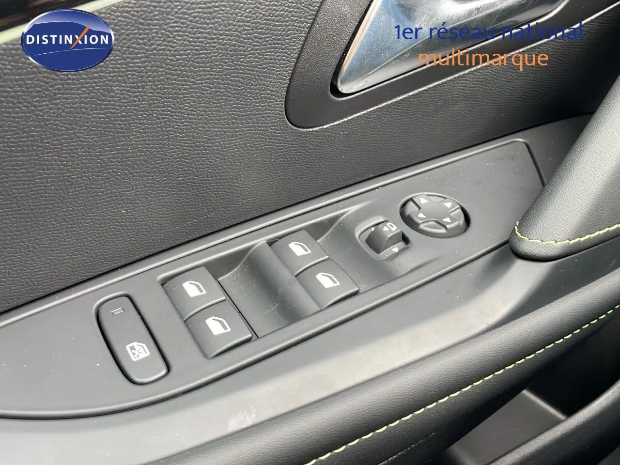 Gros plan sur les commandes des vitres électriques et rétroviseurs côté gauche intérieur d'une Peugeot 208 gris sélénium toit noir.