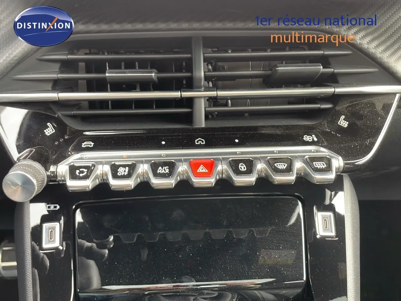 Gros plan sur la console centrale de la Peugeot 208 1.2 PureTech 2025, avec boutons de commande et aérateurs noirs brillants.