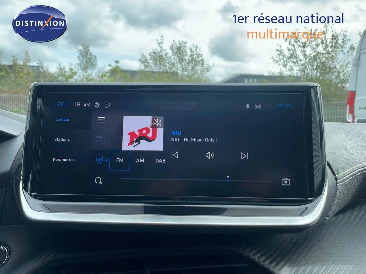 Écran tactile central de la Peugeot 208 2025 affichant la radio NRJ avec interface moderne et tableau de bord noir.