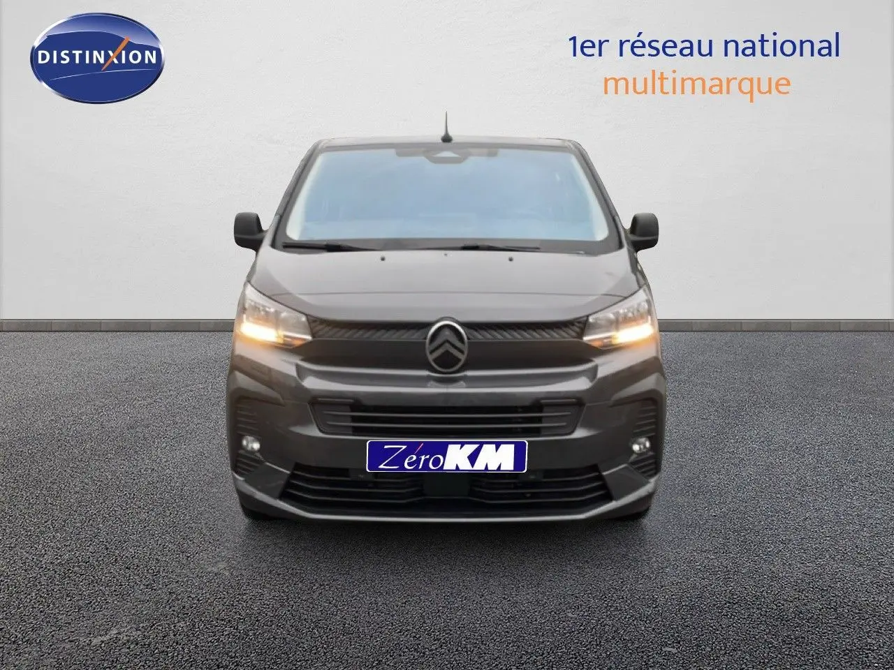 Vue frontale du Citroën Jumpy cabine approfondie gris titane métal avec feux allumés sur fond neutre.