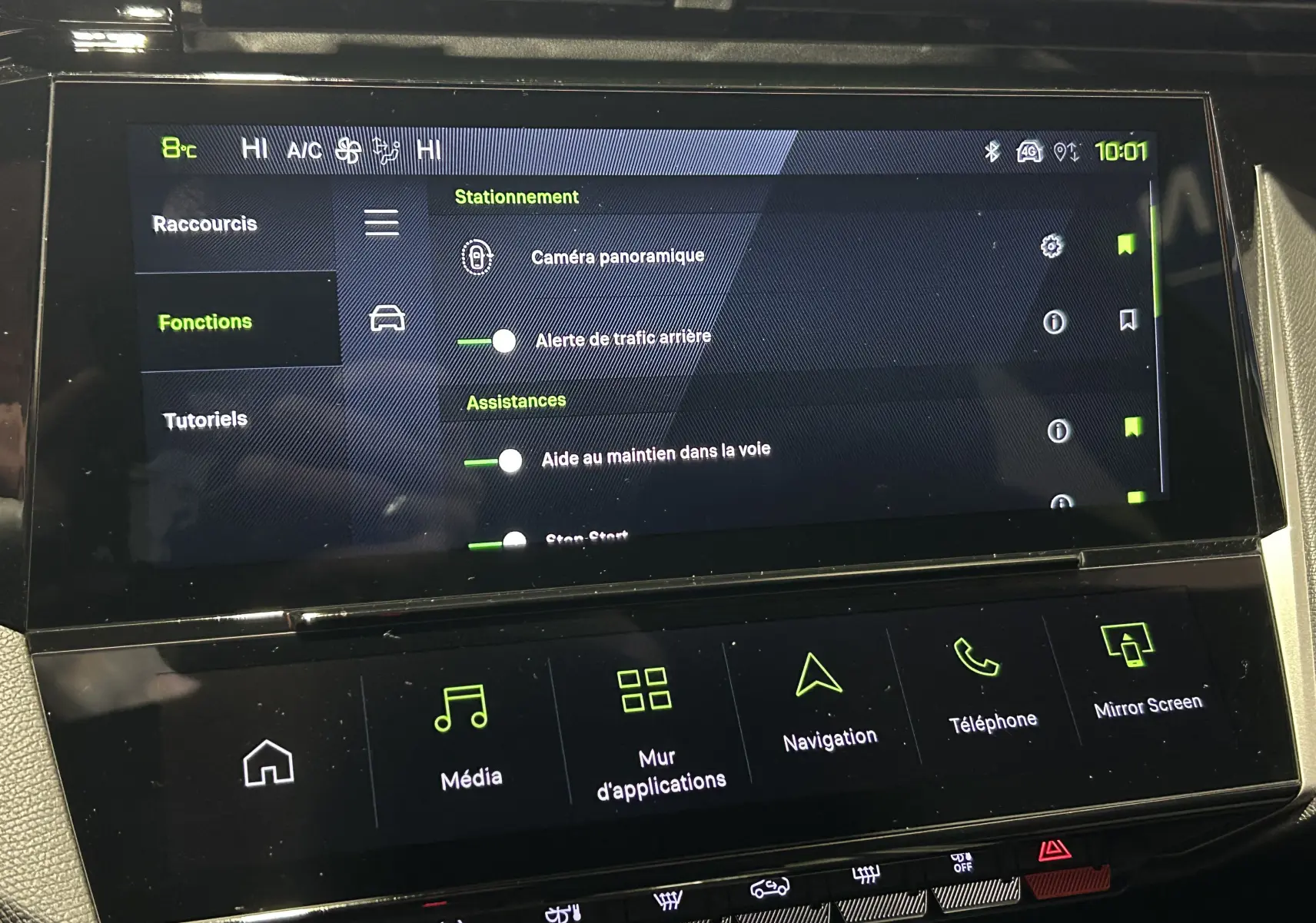 Écran tactile central de la Peugeot 308 blanc Okenite, affichant les options d’assistance à la conduite et stationnement.