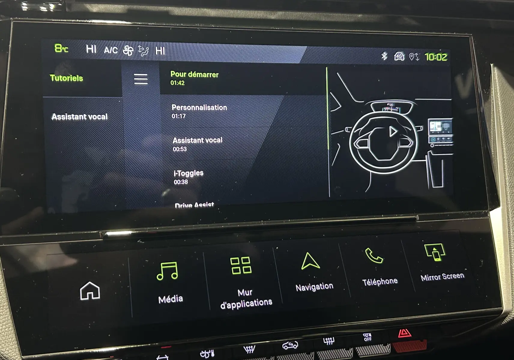 Écran tactile central de la Peugeot 308 Hybrid 2026 affichant les tutoriels et commandes multimédia en intérieur noir.