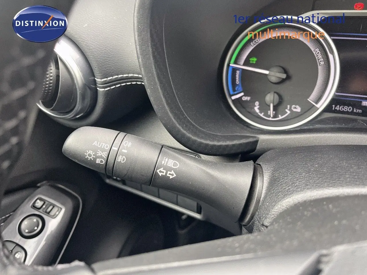 Gros plan sur la commande des phares et clignotants à gauche du volant du Nissan Juke blanc nacré 2024 hybride.