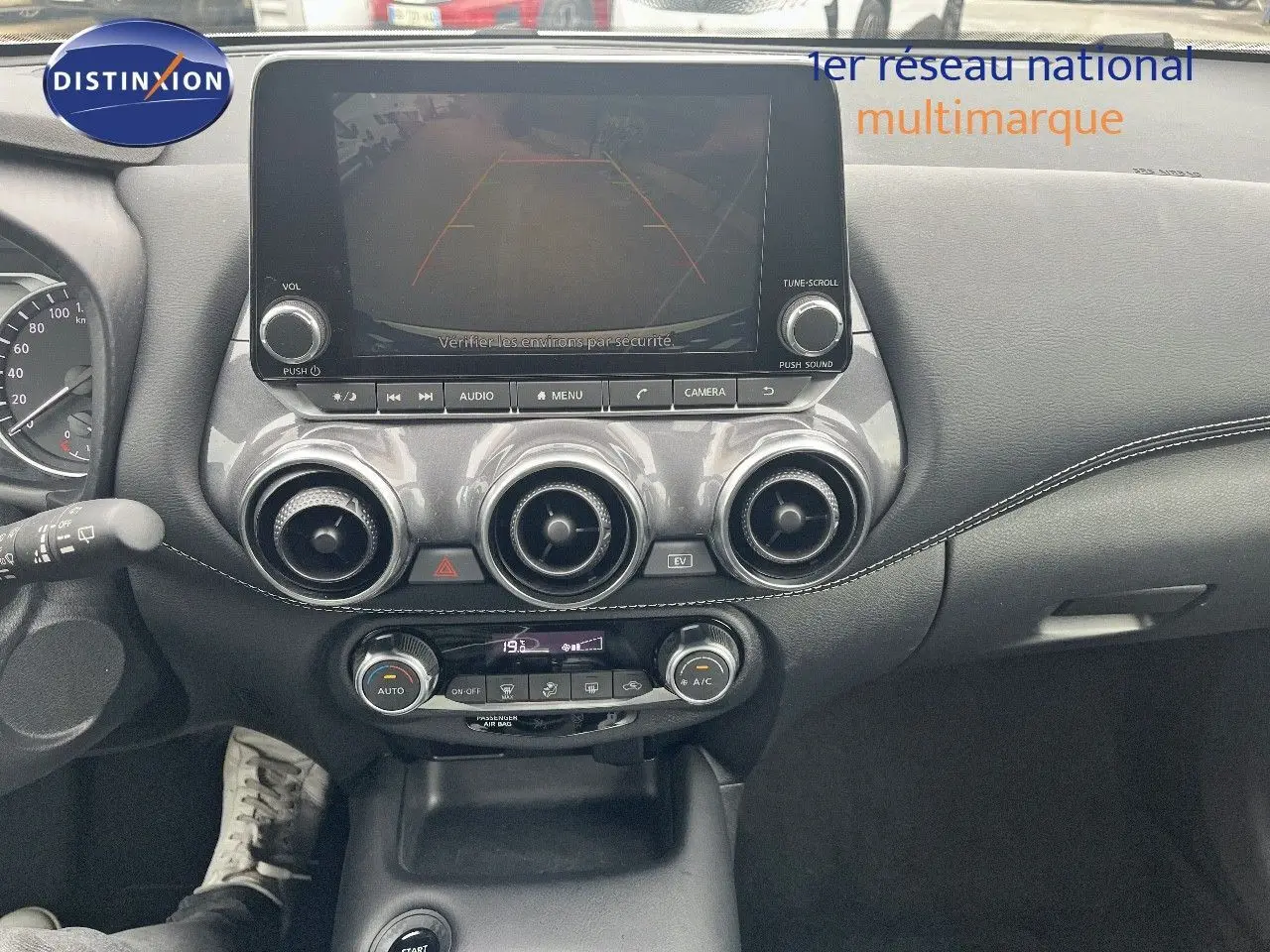 Tableau de bord du Nissan Juke blanc nacré 2024, vue frontale centrée sur l'écran tactile et les aérateurs ronds.