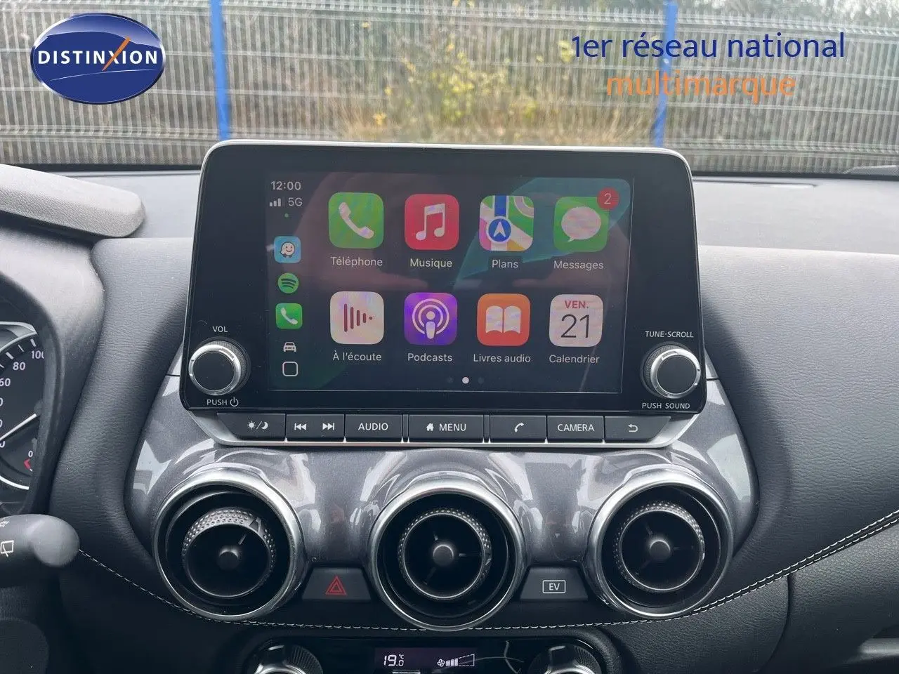 Écran tactile central avec interface Apple CarPlay sur tableau de bord gris du Nissan Juke blanc nacré 2024.