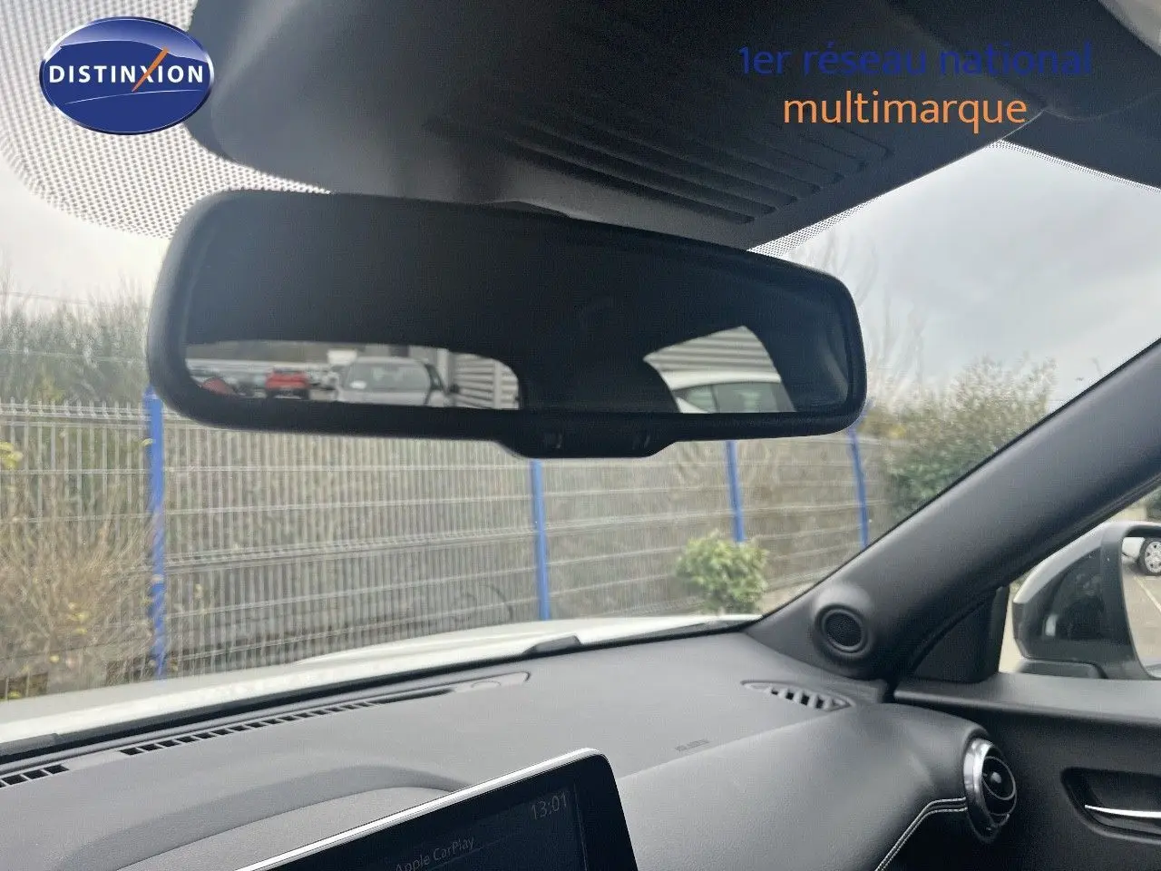 Vue intérieure du tableau de bord et rétroviseur d'une Nissan Juke blanc nacré 2024, côté droit visible.