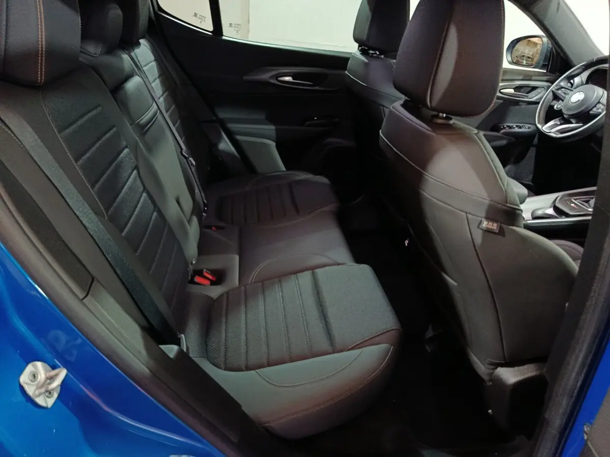 Vue intérieure côté gauche montrant la banquette arrière noire et partie avant du siège conducteur d'une Alfa Romeo Tonale bleu 2023.