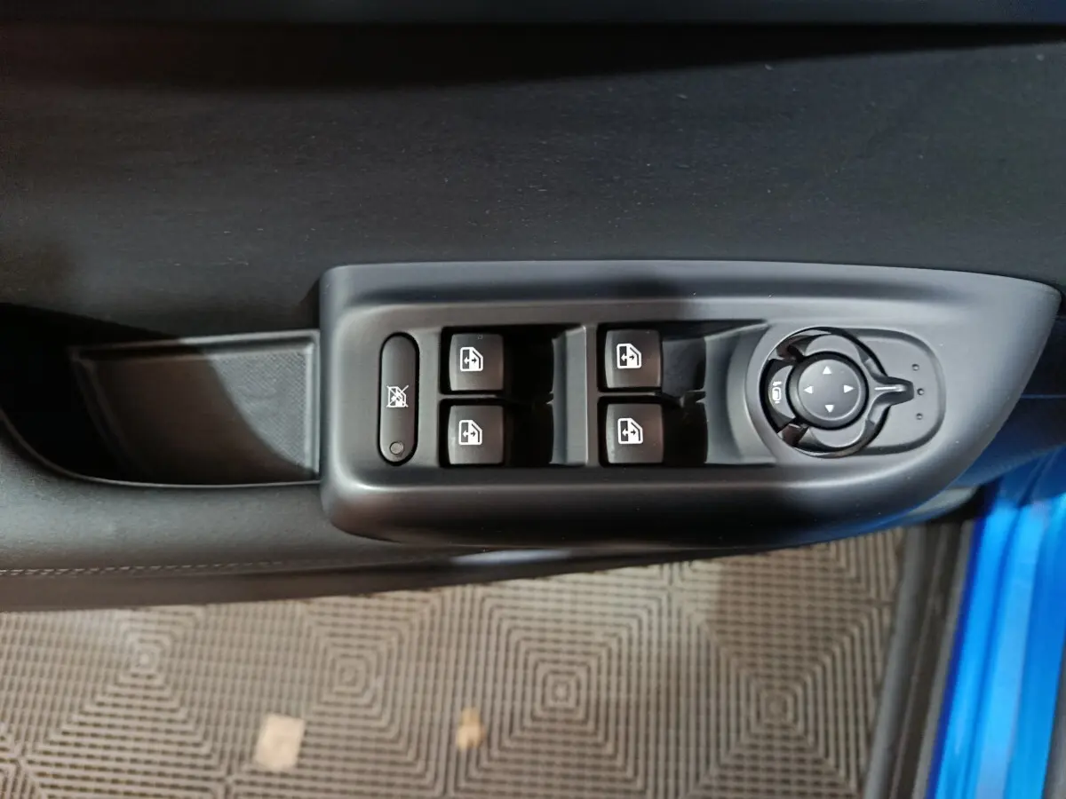 Vue rapprochée des commandes des vitres et rétroviseurs sur la porte côté conducteur d'une Alfa Romeo Tonale bleu.