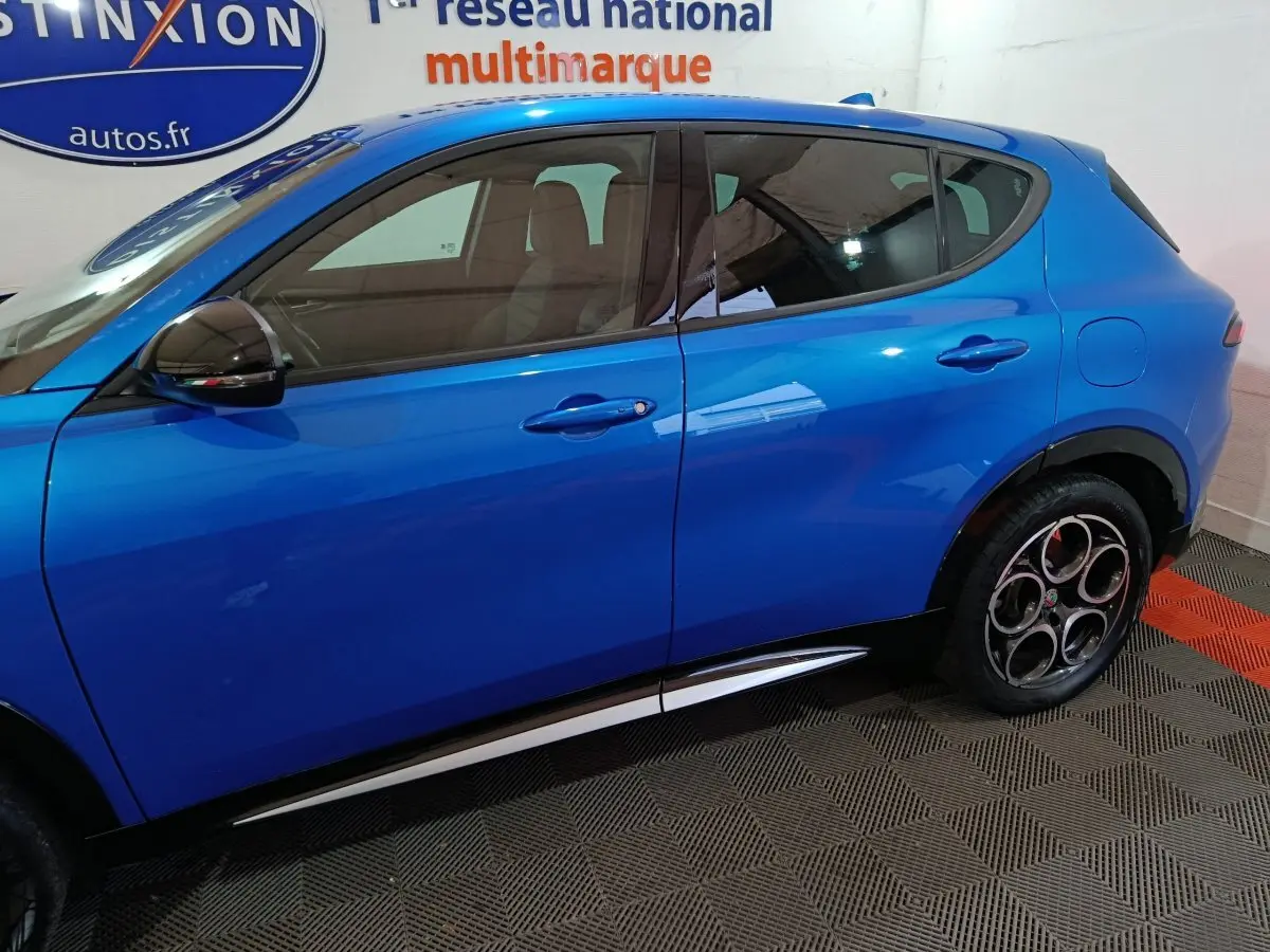 Vue latérale gauche d'un Alfa Romeo Tonale bleu 2023 avec jantes distinctives et rétroviseurs noirs.