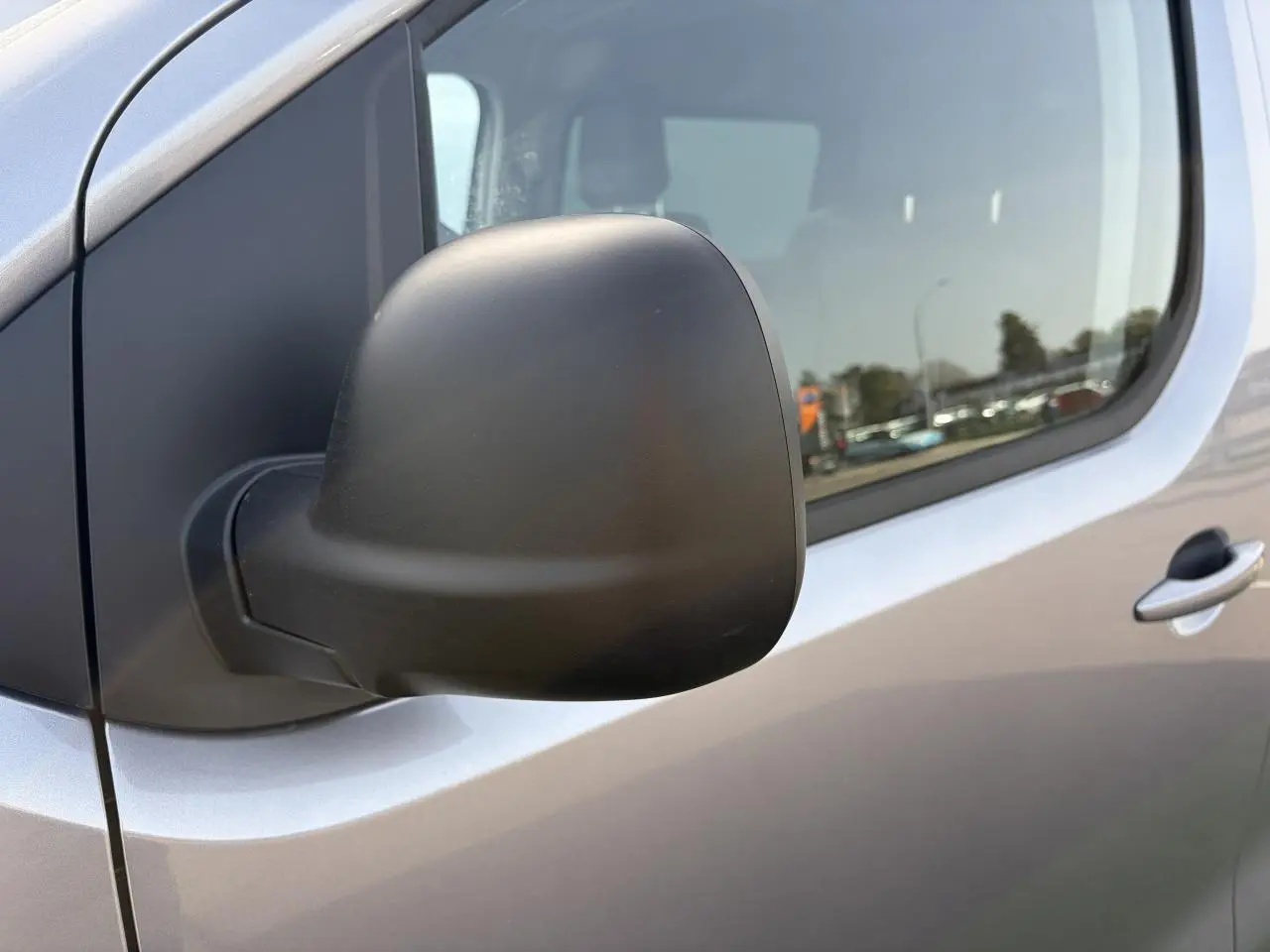 Gros plan sur le rétroviseur extérieur noir mat côté gauche du Citroën Jumpy gris acier métal.