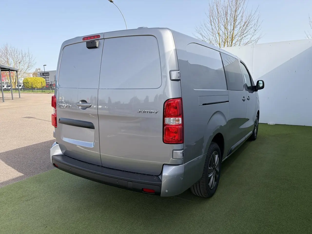 Vue 3/4 arrière droit d'un Citroën Jumpy gris acier métal avec portes arrière battantes et jantes alliage 17 pouces.