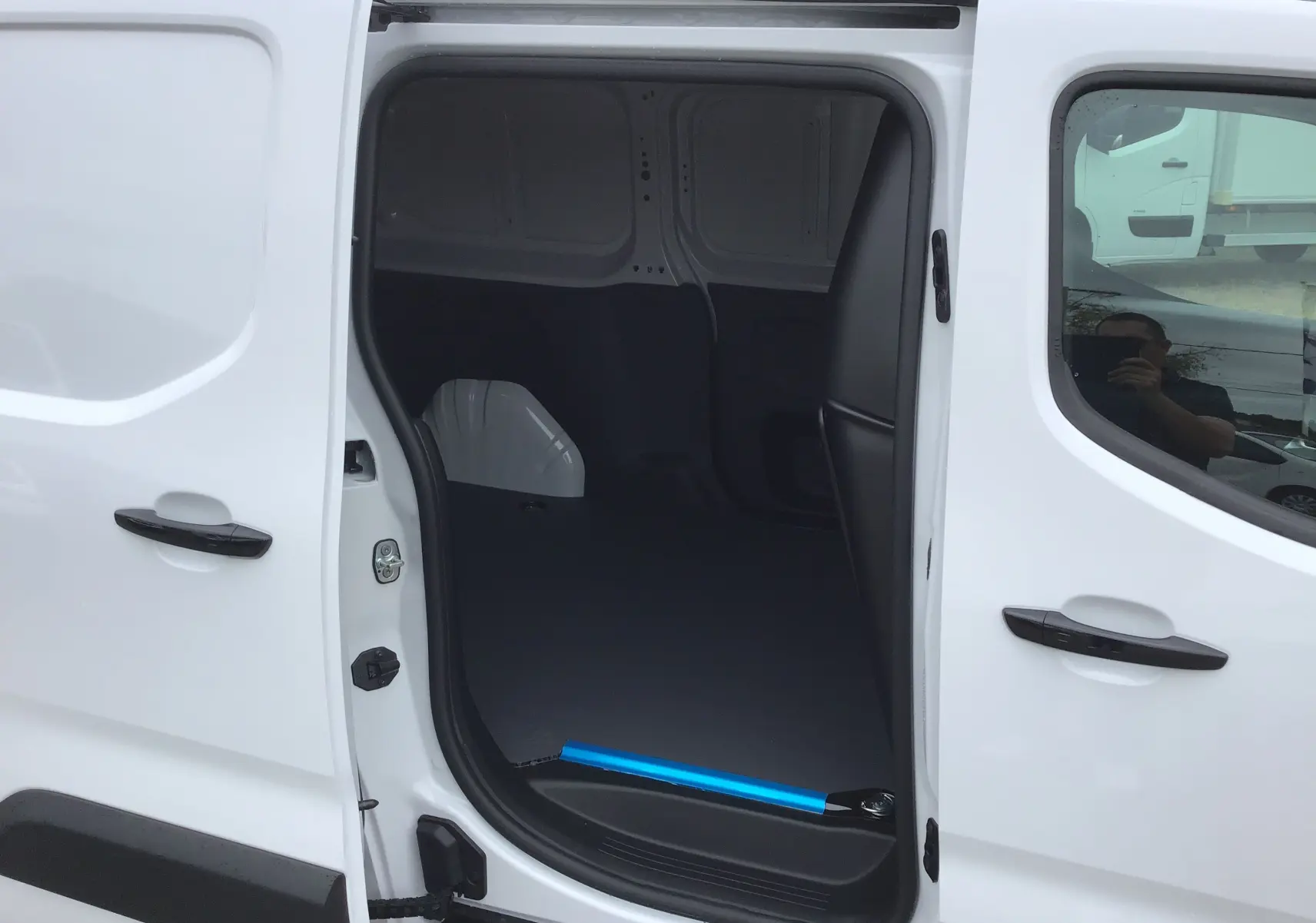 Vue latérale droite du Peugeot Partner blanc 2026 avec porte coulissante ouverte montrant l'espace de chargement vide.