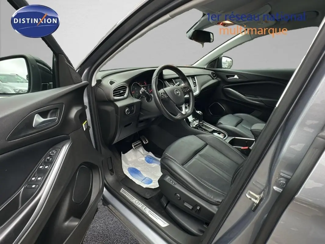 Vue intérieure côté conducteur d'un Opel Grandland X gris clair de 2020 avec sièges cuir noirs et volant multifonctions.
