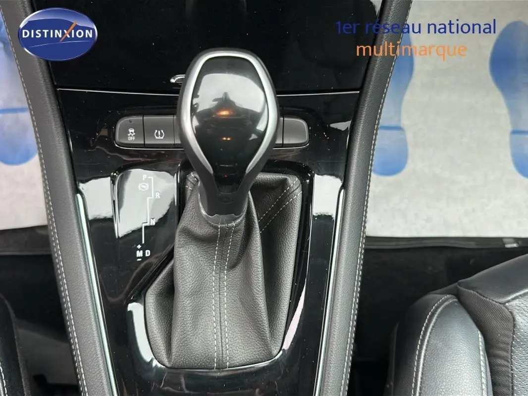 Le levier de vitesses automatique noir et cuir de l'Opel Grandland X gris clair vu de dessus, avec console brillante.