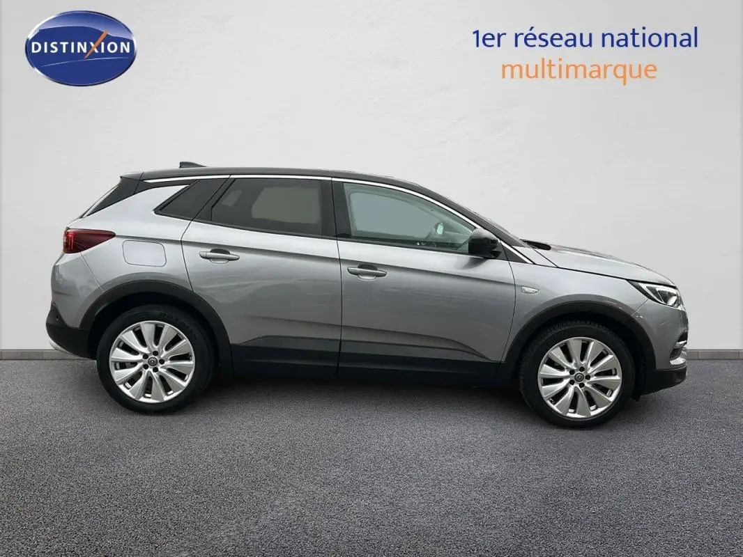 Opel Grandland X gris clair vu de profil côté gauche, avec jantes alliage 19 pouces et lignes épurées.