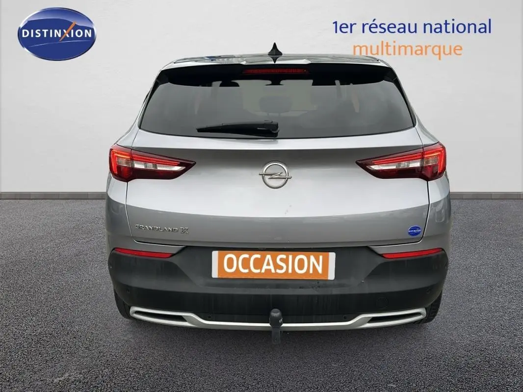 Vue arrière d'un Opel Grandland X gris clair avec attelage et feux arrière LED visibles.
