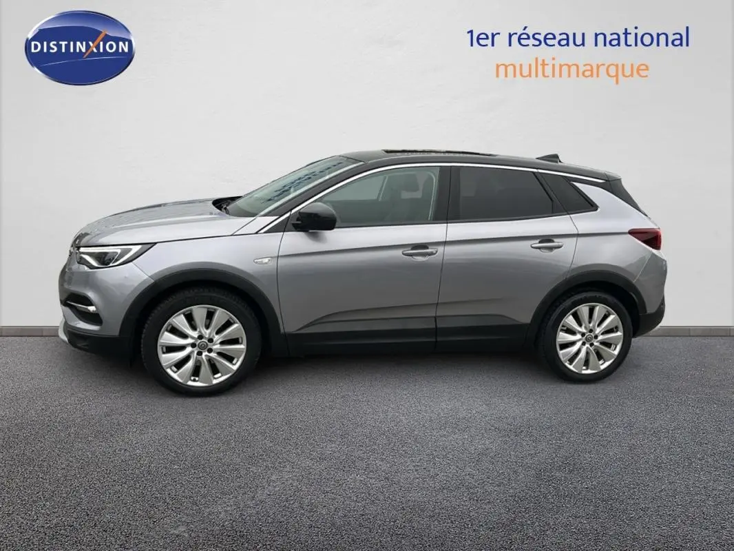 Profil côté gauche d'un Opel Grandland X gris clair de 2020 avec jantes alliage 19 pouces et toit noir.
