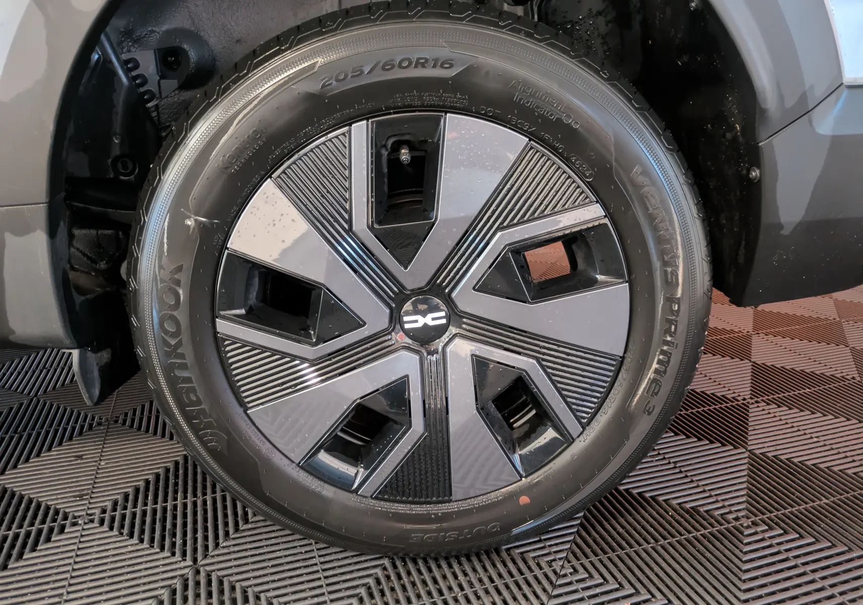 Gros plan sur la roue avant droite du Dacia Jogger gris schiste métal, mettant en valeur la jante au design moderne bicolore.