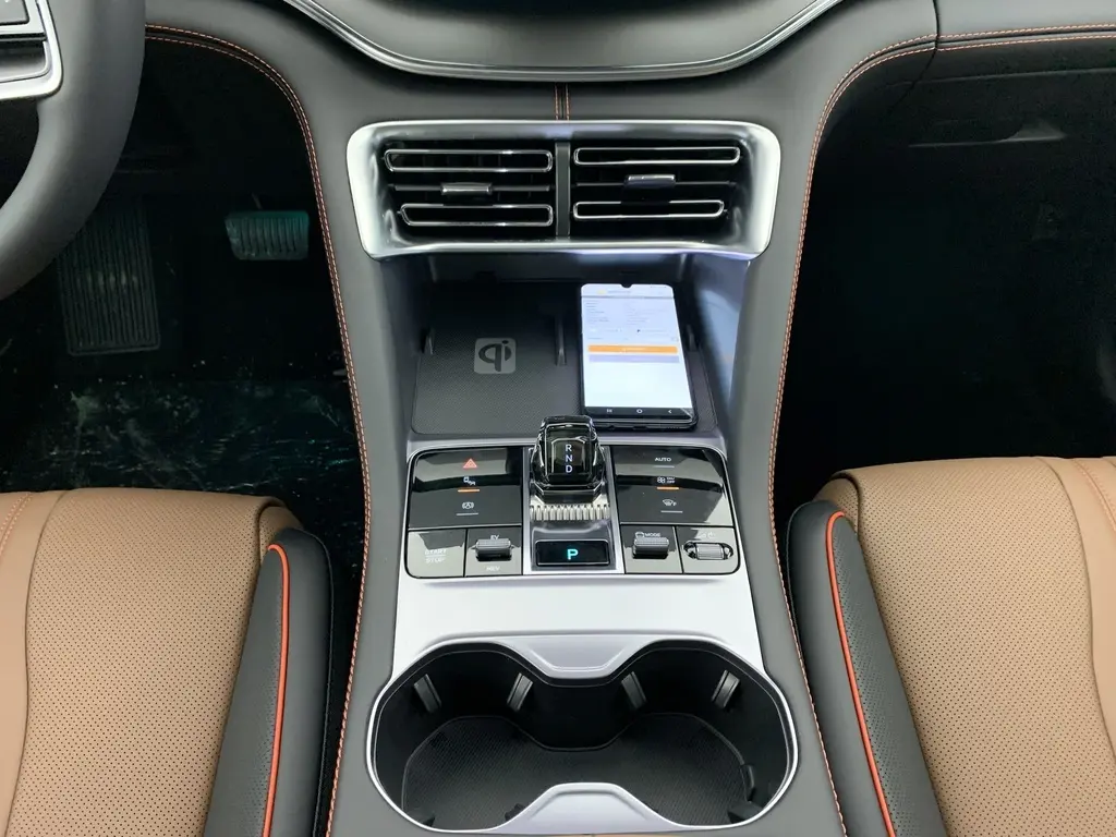 Vue intérieure du tableau de bord du BYD SEAL U 2025 avec écran tactile central et finitions noires avec surpiqûres rouges.