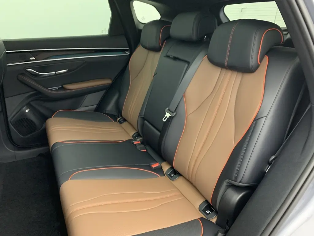 Vue intérieure côté gauche du poste de conduite du BYD SEAL U 2025, sièges en similicuir noir et marron avec surpiqûres rouges.