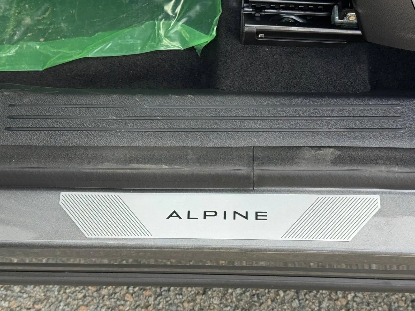 Gros plan sur la plaque de seuil de porte ALPINE du Renault Austral gris Schiste satin, intérieur noir visible.
